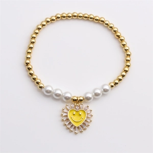 Elegante bracciale di perline dorate con perle e un ciondolo a cuore smiley giallo lucido