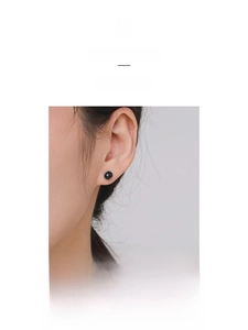 Close-up of minimalist S925 sterling silver black obsidian stud earrings worn on ear