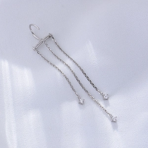 Detail of silver S925 chain tassel earrings with sparkling cubic zirconia on silk