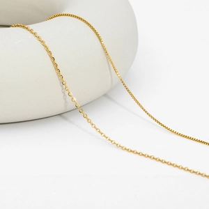 Detailed close-up showing golden box chain and cross chain links with metallic luster