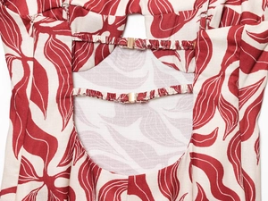 Detail of red and white printed midi dress showing hollow back design and metal buckle