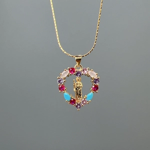 Collier avec pendentif cœur doré orné de pierres colorées et d'une image sainte