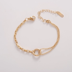 Detailed close-up of gold-plated asymmetrical chain bracelet with K18 engraved tag