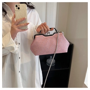 Borsa a conchiglia in strass rosa con catena d'argento portata da una modella in camicia