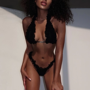 Sexy black ruffle bikini set with halter neck ties and central metal detail on model