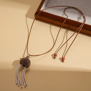 Détail d'un collier de style bohème avec perles en céramique et glands en perles blanches
