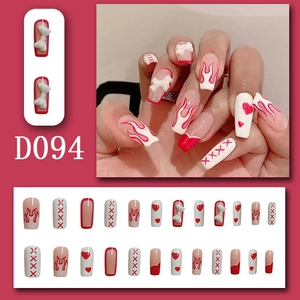 Detail of long trapezoidal press-on nails with 3D white bows and red flame patterns