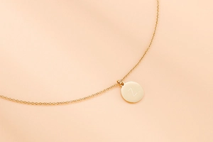 Détail macro du collier en acier doré avec pendentif gravé de la lettre Z