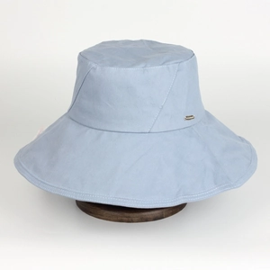 Light blue wide brim cotton bucket hat for women on a dark wood display stand