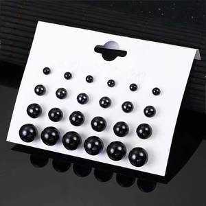 Set of 12 pairs of glossy black pearl stud earrings in various sizes on a white card