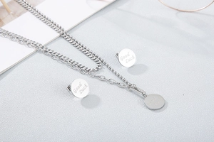 Close-up of silver multilayer necklace and earrings set with Good Luck engraving