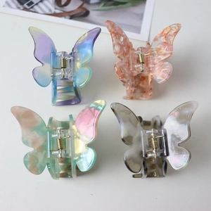 Close-up of four colorful acetate butterfly hair claws in marble and gradient finishes