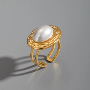 Detail of vintage 18K gold plated ring featuring a large white oval pearl and twisted frame