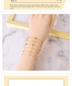 Detail of layered gold titanium bracelets featuring heart and flower charms on model