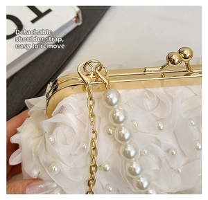 Détail de la chaîne dorée amovible et de la bandoulière en perles sur le sac en dentelle