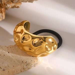 18k gold plated stainless steel hair tie with hammered texture on beige stone