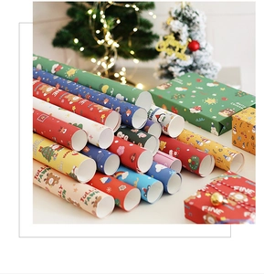 Close-up of stacked Christmas wrapping paper with reindeer patterns and a festive gift box