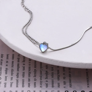 Detail of double-layer moonstone heart pendant necklace with snake and bead chain link