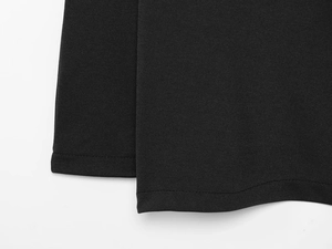 Close-up of black fabric texture and professional stitching on an A-line skirt