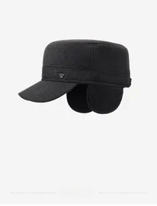Detail of winter flat top cadet hat with foldable ear flaps and metal logo badge