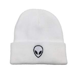 Detailed close-up of white ribbed knit beanie featuring alien head embroidery