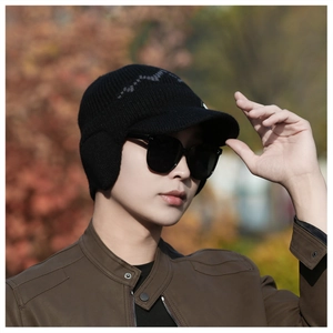 Close-up of men's winter knit hat with ear flaps and brim, thick warm black wool beanie