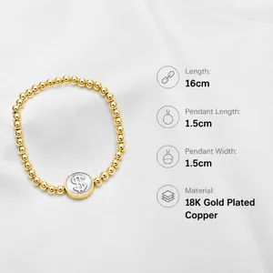 Detail of 18k gold plated beaded bracelet with a 1.5cm dollar sign charm pendant