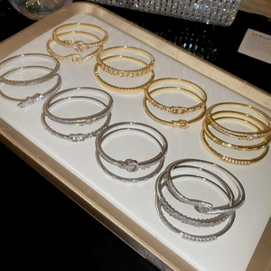Detailed view of 18k gold plated bracelets with zircon inlay and horseshoe buckle design