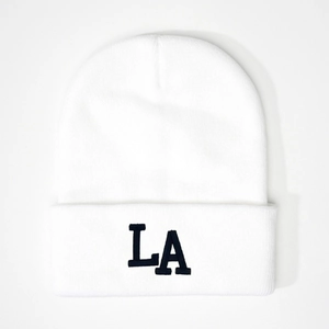 Detailed view of white knit beanie featuring 3D black LA embroidery and ribbed cuff texture