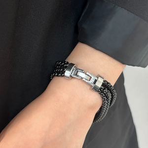 Detail of multi-layer black beaded bracelet with silver metal buckle on a wrist