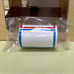 Macro detail of self-adhesive label roll in red and blue border design for name tags