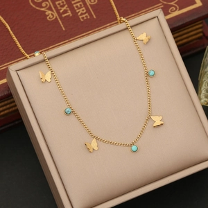 Macro shot of gold butterfly necklace with turquoise stones on a jewelry box