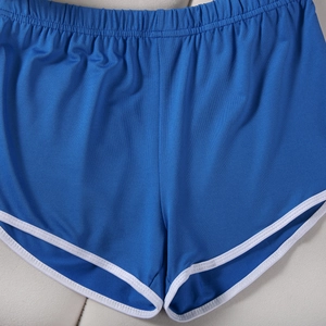 Detail of blue athletic shorts with white piping and elastic waistband flat lay