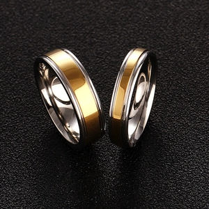 Two-tone 316L titanium steel rings with gold and silver finish on a dark background