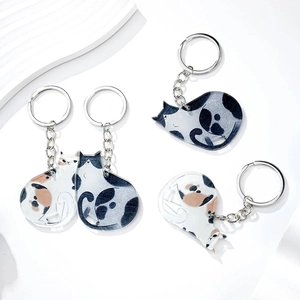 Close-up of cute cat acrylic keychains featuring black-white and orange patterns