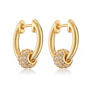 Detail of gold-plated hoop earrings with micro-paved cubic zirconia spheres on white base