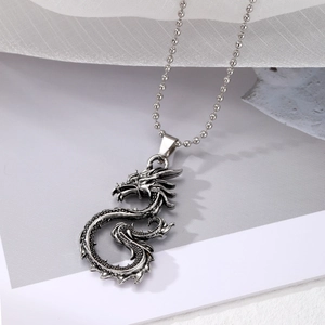 Macro close-up of a vintage punk dragon pendant in silver finish on a metal bead chain