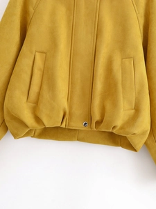 Close-up of yellow faux suede jacket featuring zipper details and soft fabric texture