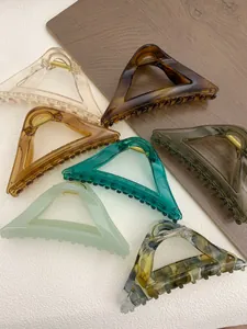 Detail of a large triangular hair claw clip with gradient amber and tortoiseshell patterns