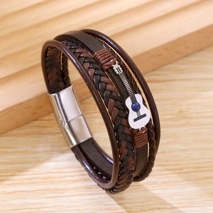 Détail du bracelet multicouche en cuir marron avec guitare argentée et pierre bleue