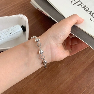 Close-up of heart-shaped silver bracelet on wrist with elegant minimalist design
