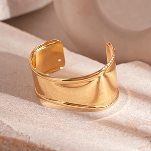 Minimalist wide gold metallic open cuff bracelet with irregular geometric glossy finish