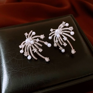 Detailed macro shot of fireworks pearl earrings with zircon on a black leather jewelry box