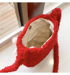 Detail of red plush bucket bag showing beige canvas lining and magnetic snap closure