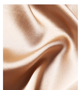Macro shot of smooth champagne silk fabric texture with elegant satin sheen and soft folds