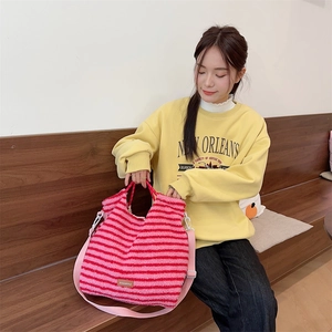 Detail of pink and red striped plush tote bag with lamb wool texture and pink shoulder strap