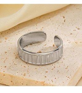 Dettaglio anello regolabile argento con strisce verticali su base in pietra beige