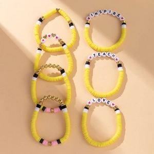 Detail of colorful polymer clay bead bracelets with INSPIRE and TEACH letter beads