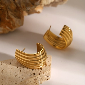 Classic 18k gold plated stainless steel ribbed C-shape earrings on a stone base