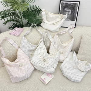 Collection of printed canvas hobo bags with star and polka dot patterns on a soft sofa